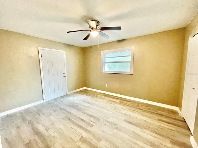 unfurnished room with a ceiling fan, baseboards, and wood finished floors