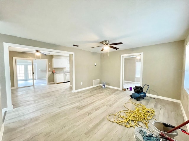 empty room featuring light wood-type flooring, baseboards, visible vents, and a ceiling fan