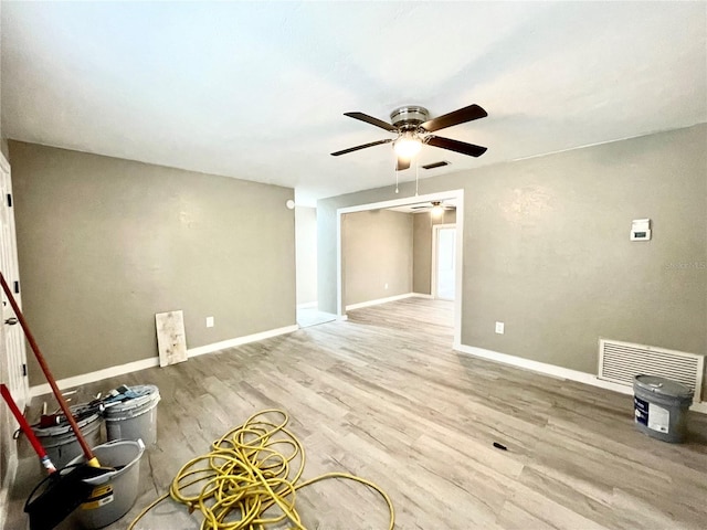 empty room featuring baseboards, visible vents, ceiling fan, and wood finished floors