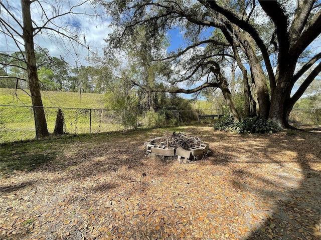 view of yard featuring fence and a fire pit