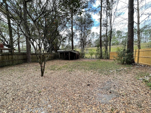 view of yard with a fenced backyard and an outbuilding