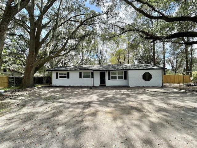 ranch-style house featuring fence