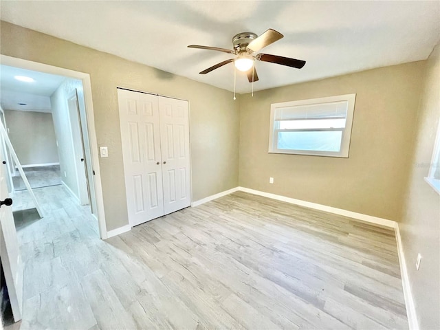 unfurnished bedroom featuring a closet, baseboards, and wood finished floors