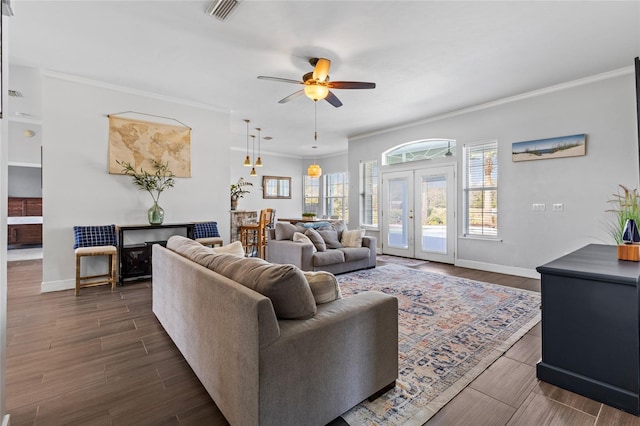 living area with wood tiled floor, visible vents, crown molding, and french doors