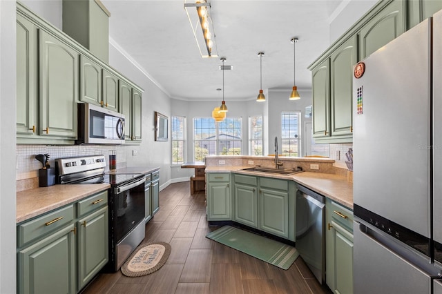 kitchen featuring appliances with stainless steel finishes, a sink, and green cabinets