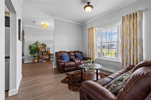 living area with baseboards, crown molding, and wood finished floors