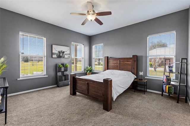 bedroom featuring carpet floors, ceiling fan, multiple windows, and baseboards