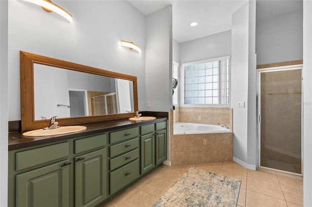 bathroom featuring double vanity, a stall shower, a sink, and tile patterned floors