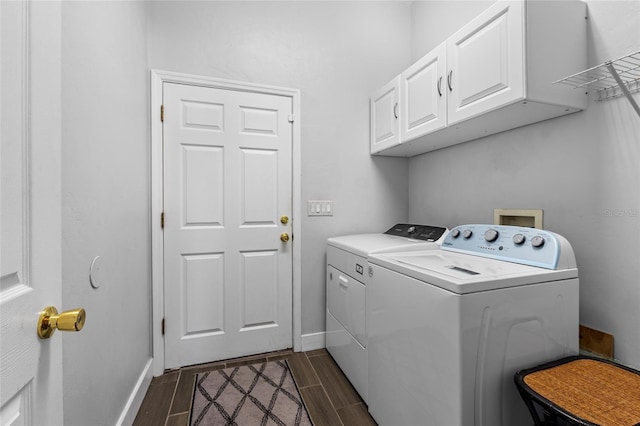 laundry area featuring cabinet space, wood tiled floor, baseboards, and washer and clothes dryer