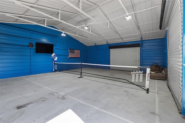 exterior space featuring lofted ceiling, metal wall, and concrete flooring