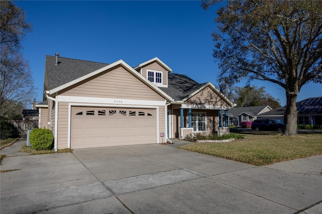 view of front facade with a shingled roof, a front yard, a garage, and concrete driveway