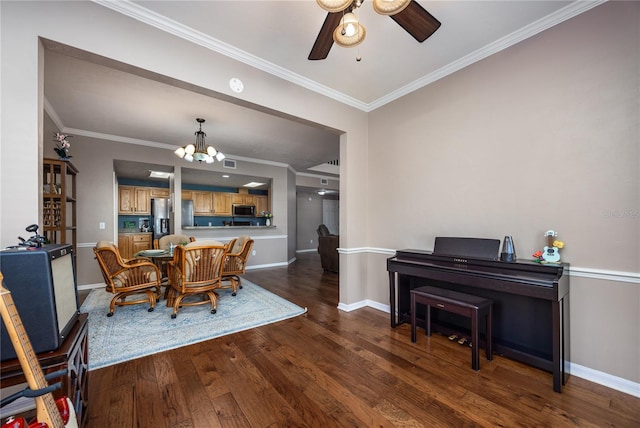 dining area featuring hardwood / wood-style floors, visible vents, baseboards, ornamental molding, and ceiling fan with notable chandelier