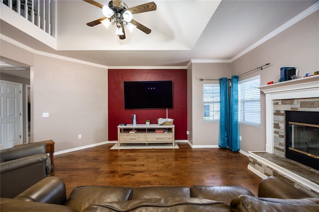 living area with baseboards, a stone fireplace, wood finished floors, and ornamental molding