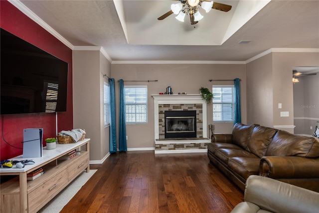 living room featuring a stone fireplace, ceiling fan, baseboards, and wood-type flooring