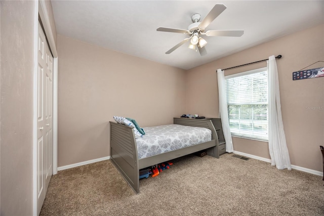 carpeted bedroom featuring a ceiling fan, baseboards, visible vents, and a closet