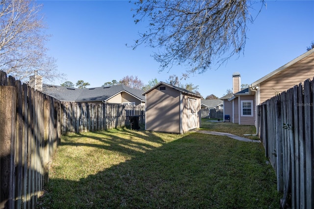 view of yard with an outbuilding, a fenced backyard, and a storage shed