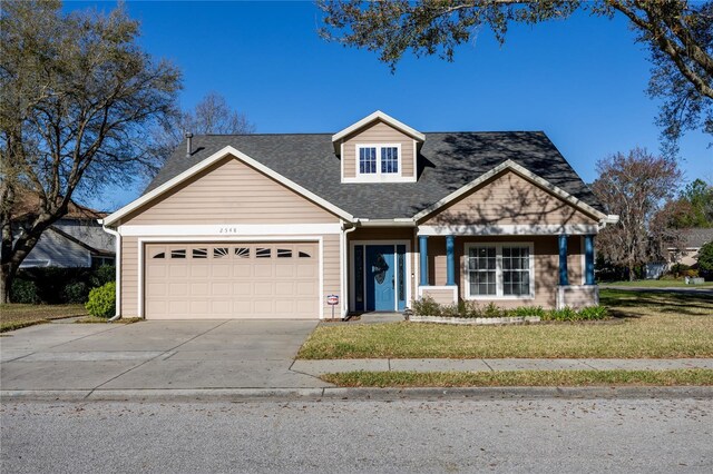 view of front of house featuring concrete driveway, an attached garage, a front lawn, and roof with shingles