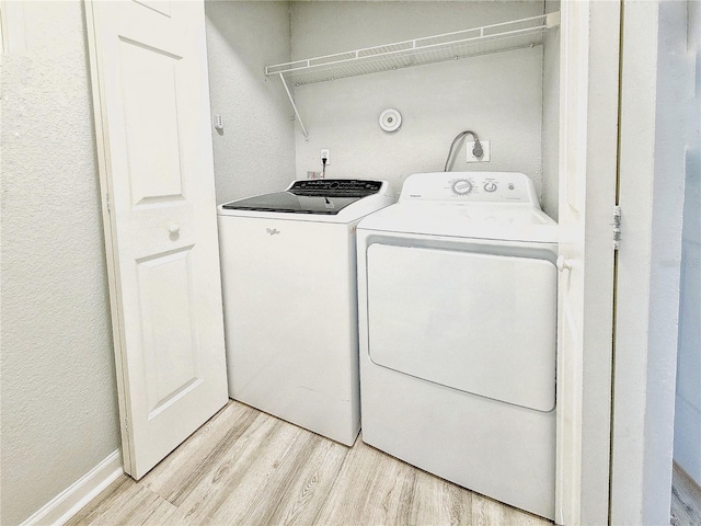 washroom featuring laundry area, light wood-style floors, and washer and dryer