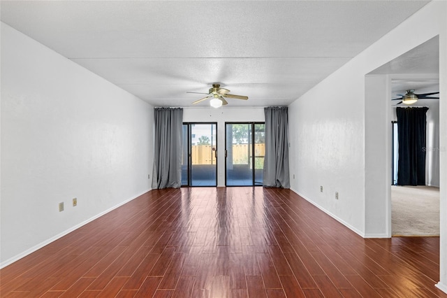 empty room featuring a textured ceiling, ceiling fan, and wood finished floors