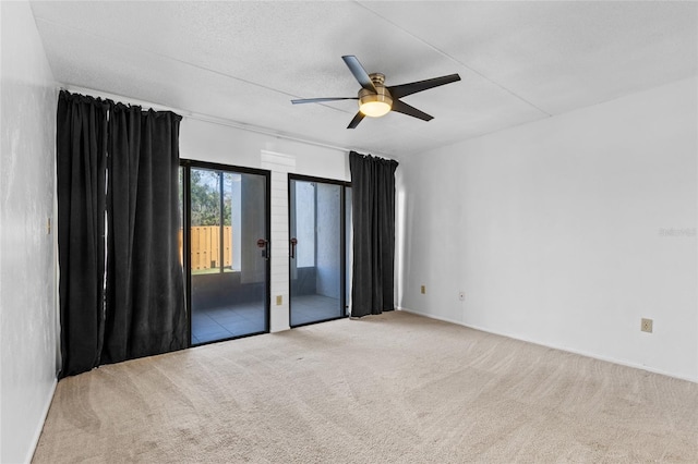 empty room with a textured ceiling, carpet flooring, and a ceiling fan