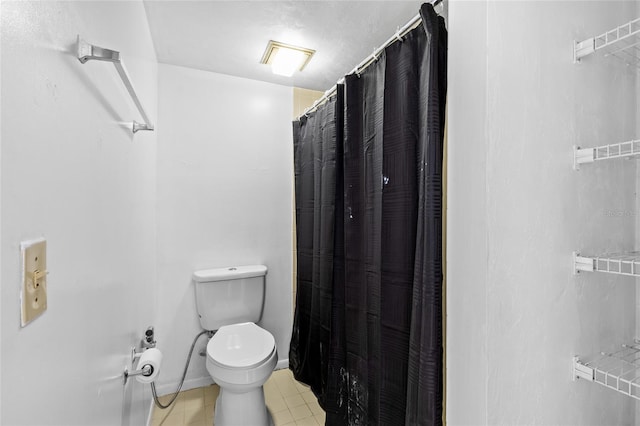 bathroom with baseboards, a shower with shower curtain, and toilet