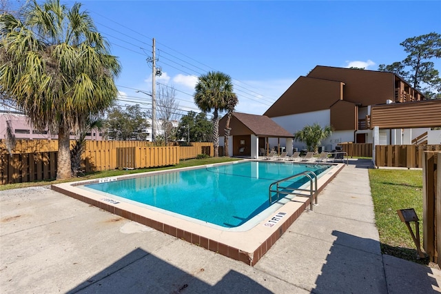 community pool featuring fence and a patio