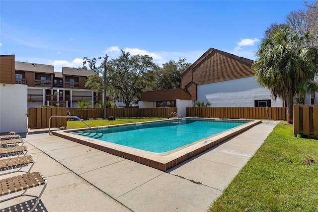 pool featuring a lawn and a fenced backyard