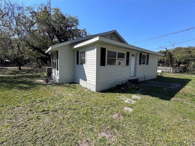 view of front of house with entry steps and a front lawn