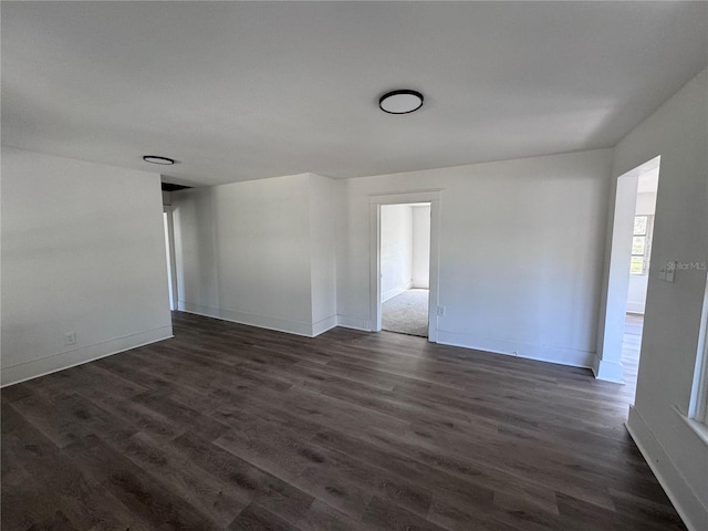 unfurnished room with dark wood-style floors and baseboards