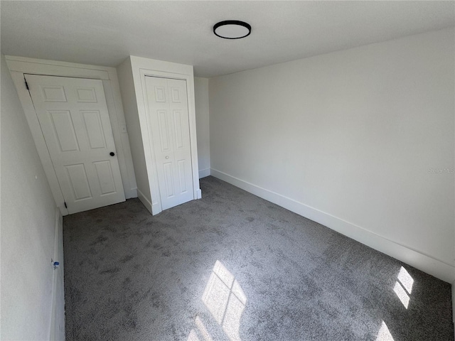 unfurnished bedroom with carpet floors, baseboards, and a closet