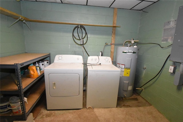 laundry area with concrete block wall, laundry area, water heater, and washing machine and clothes dryer