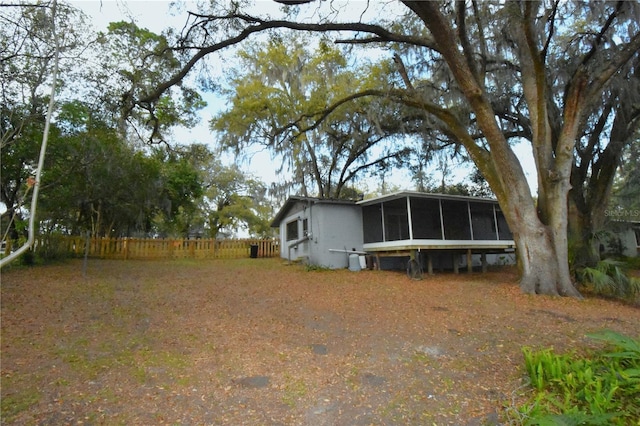 view of yard with fence and a sunroom