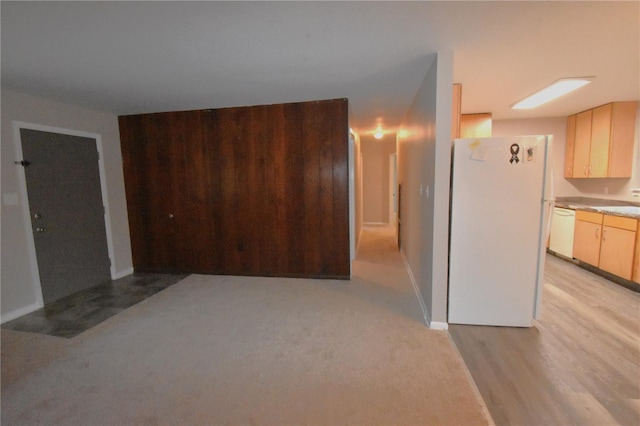 interior space featuring light countertops, light wood-style flooring, light brown cabinetry, white appliances, and baseboards