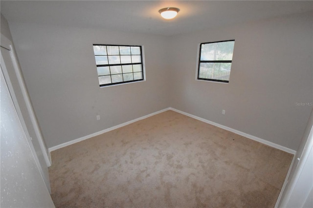 spare room featuring carpet floors and baseboards