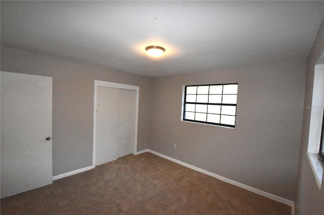 unfurnished bedroom featuring carpet floors, a closet, and baseboards