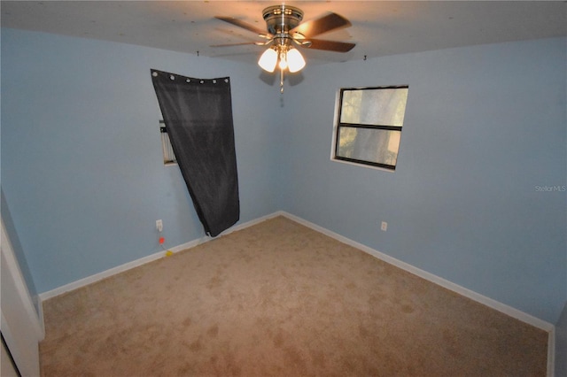 empty room with ceiling fan, carpet flooring, and baseboards