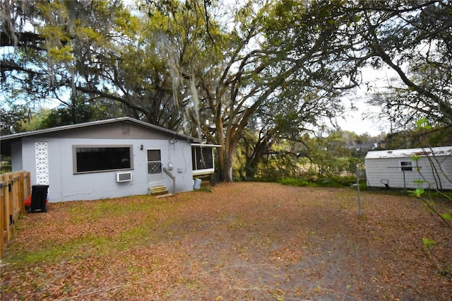 rear view of property featuring a wall mounted air conditioner