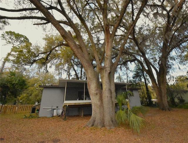 back of property with a sunroom and fence