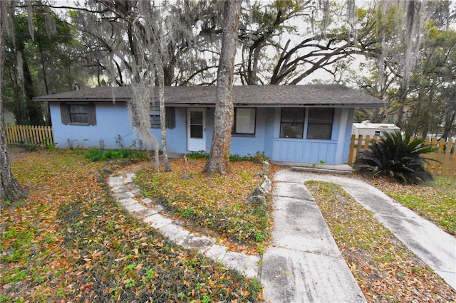 ranch-style home featuring fence