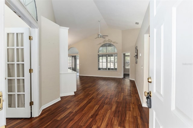 foyer entrance featuring arched walkways, baseboards, dark wood finished floors, a ceiling fan, and lofted ceiling