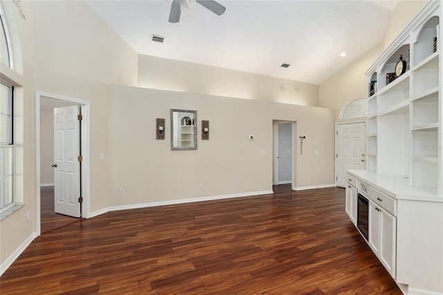 unfurnished living room with high vaulted ceiling and dark wood finished floors