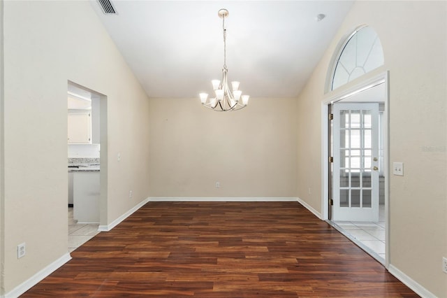 interior space with a chandelier, lofted ceiling, visible vents, and wood finished floors