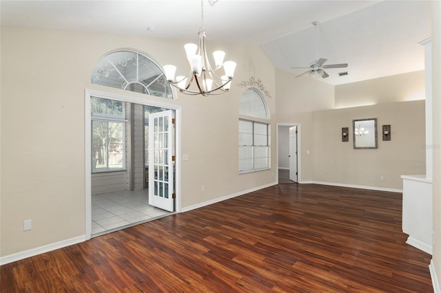 empty room with high vaulted ceiling, ceiling fan with notable chandelier, visible vents, and wood finished floors