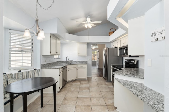 kitchen with light tile patterned floors, white cabinets, lofted ceiling, stainless steel appliances, and a sink