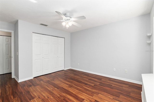 unfurnished bedroom with baseboards, visible vents, a ceiling fan, wood finished floors, and a closet