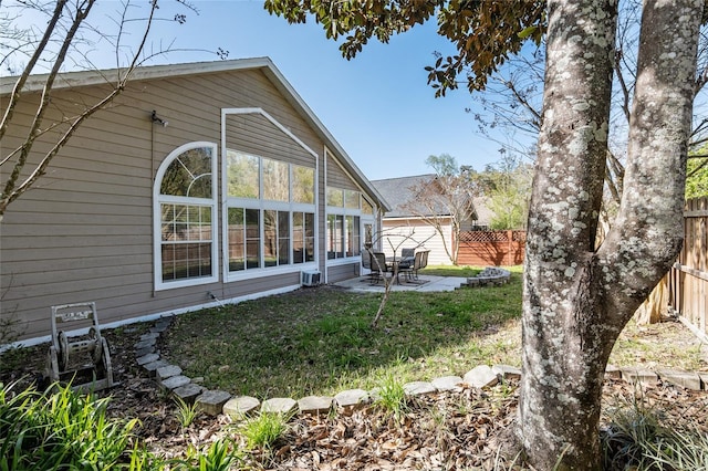 rear view of house with a patio area, fence, and a yard