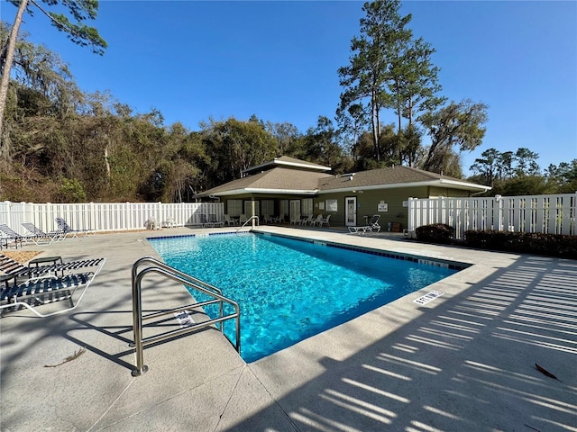 community pool with fence and a patio