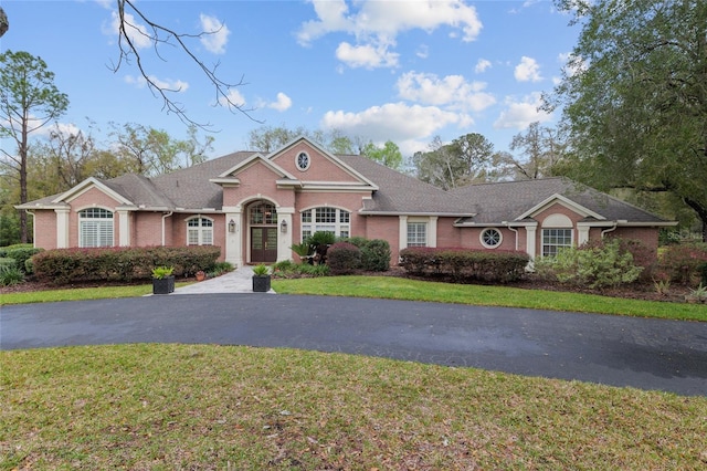 view of front of property featuring brick siding and a front yard