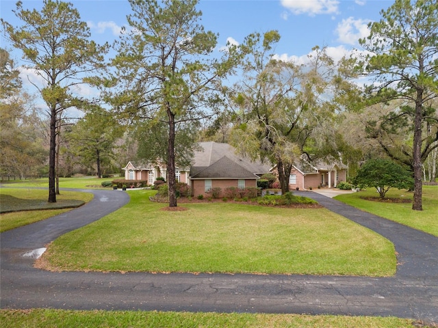 view of front of house featuring aphalt driveway, an attached garage, and a front yard