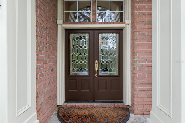 view of exterior entry with french doors and brick siding